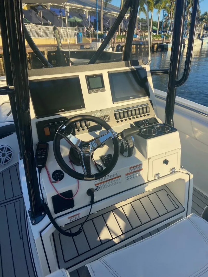 Slide: The Image of 2021 Blackfin 252 boat dashboard with steering wheel, controls, and navigation screens. - 5
