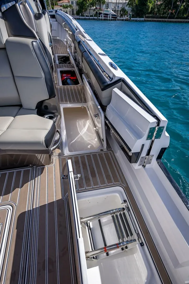 Slide: The Image of 2023 Nor-Tech 500 Sport boat interior with open storage compartments and seating. - 18