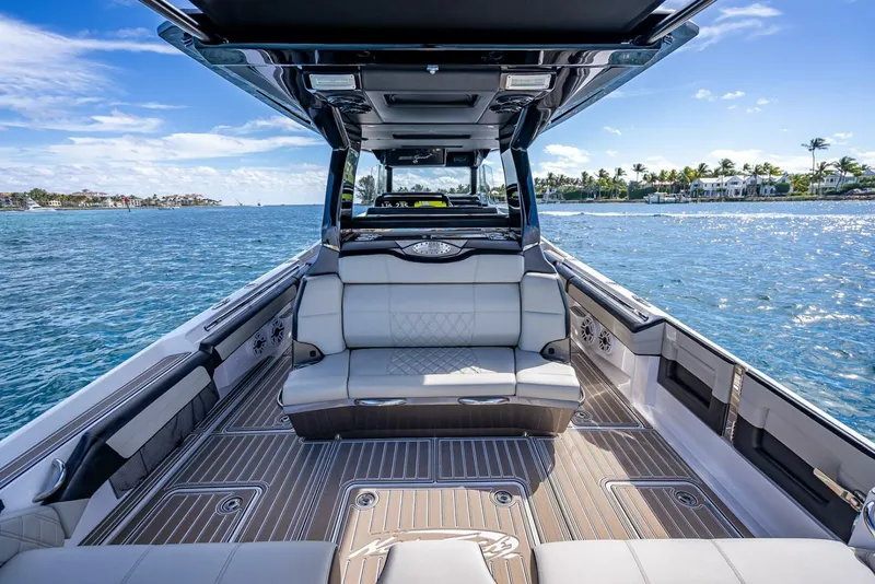 Slide: The Image of 2023 Nor-Tech 500 Sport boat interior with luxurious seating on a sunny day. - 22