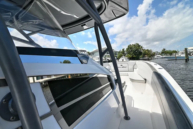 Slide: The Image of 2020 Nor-Tech 340 Sport boat docked, showcasing sleek design and spacious deck. - 11