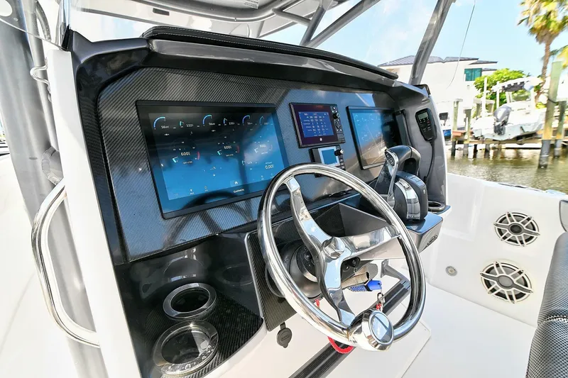 Slide: The Image of 2020 Nor-Tech 340 Sport boat dashboard with modern controls and steering wheel. - 13
