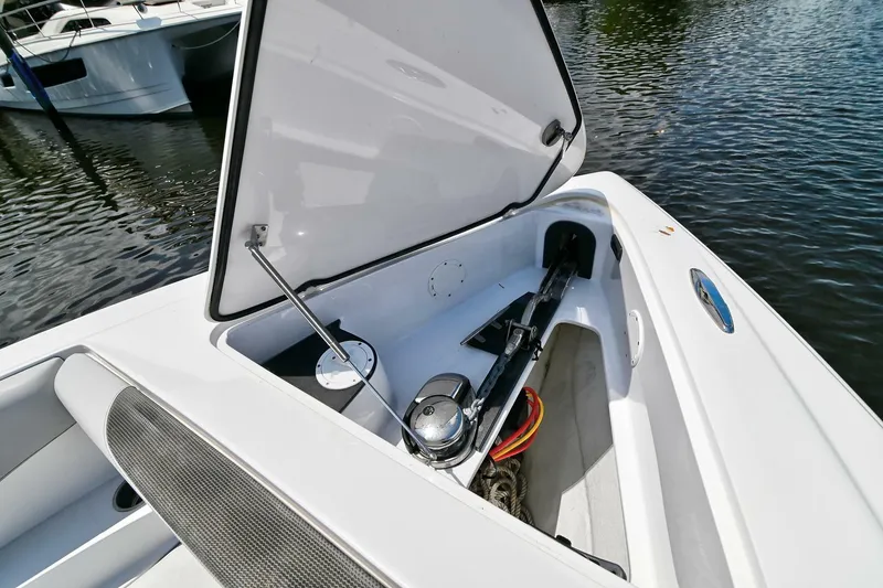 Slide: The Image of 2020 Nor-Tech 340 Sport boat storage compartment open by the water. - 15