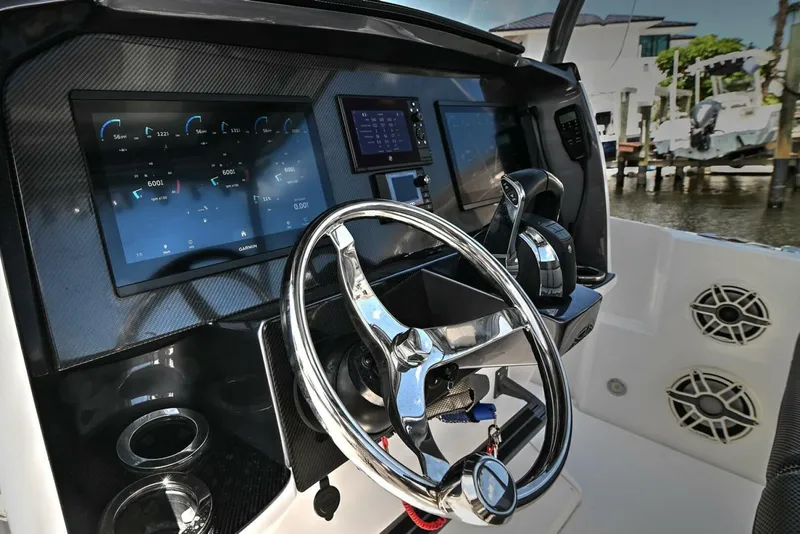 Slide: The Image of 2020 Nor-Tech 340 Sport boat dashboard with steering wheel and digital displays. - 19