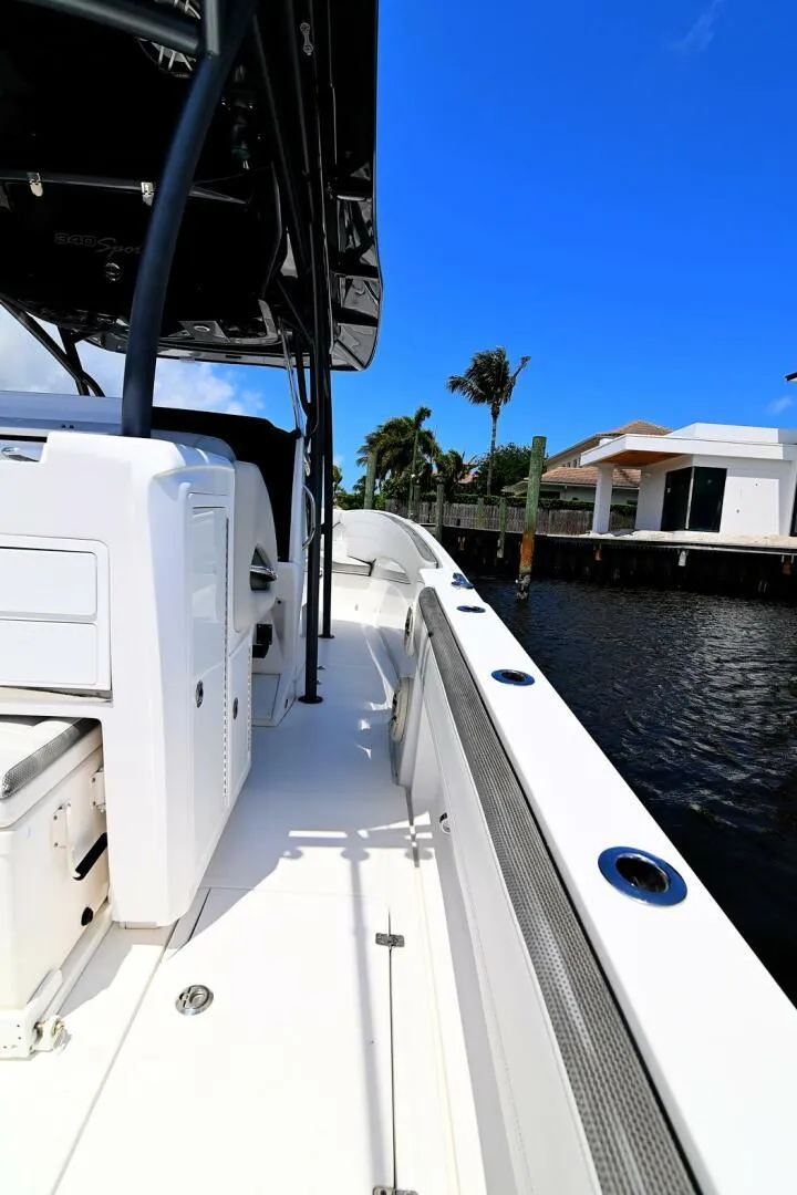 Slide: The Image of 2020 Nor-Tech 340 Sport boat docked by waterfront homes under clear blue sky. - 23
