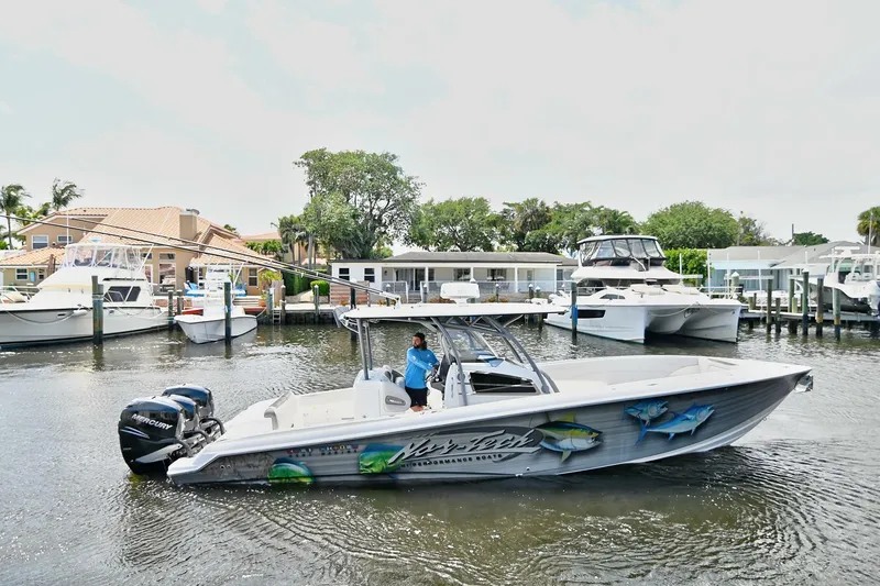 Slide: The Image of 2020 Nor-Tech 340 Sport boat docked in a marina with scenic waterfront homes. - 33