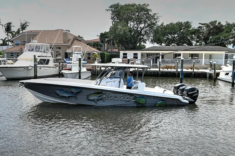 Slide: The Image of 2020 Nor-Tech 340 Sport boat docked in a marina with waterfront homes. - 34