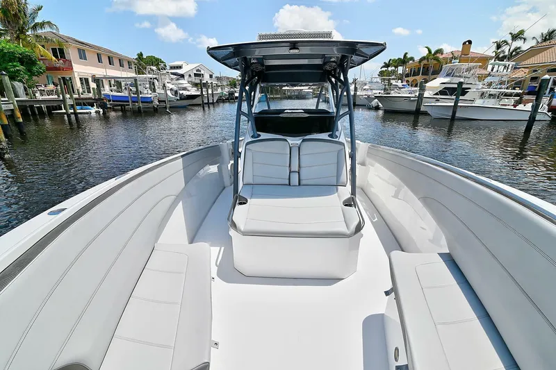 Slide: The Image of 2020 Nor-Tech 340 Sport boat with sleek seating, docked in a marina under a clear sky. - 7