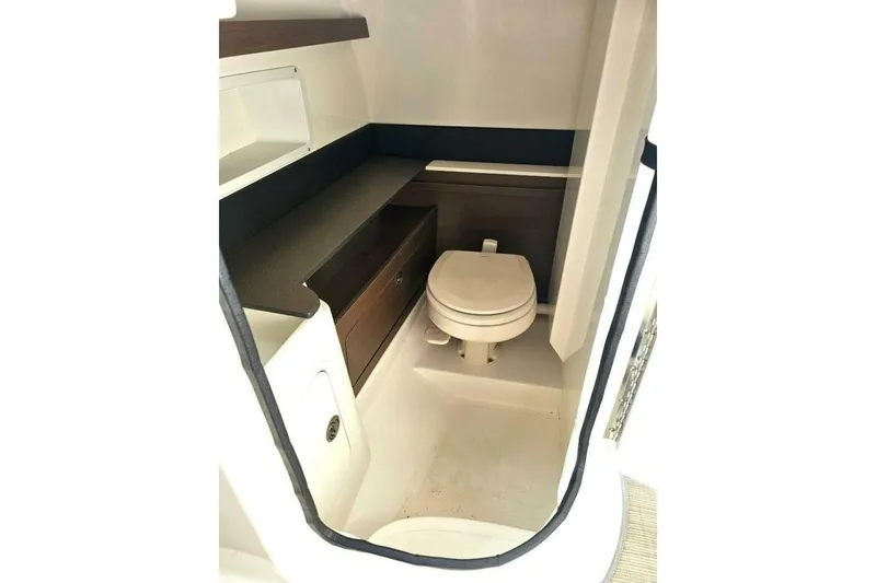 Slide: The Image of 2018 Sea Ray SDX 290 Outboard boat interior bathroom with toilet and storage. - 15