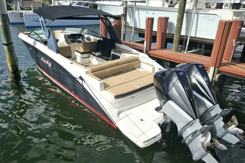 Slide: The Image of 2018 Sea Ray SDX 290 Outboard boat docked, featuring dual engines and spacious seating. - 9