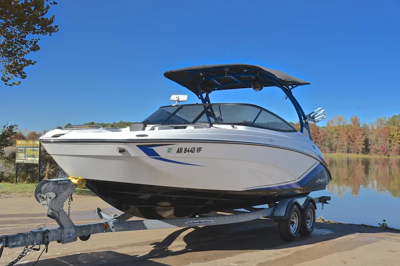 Slide: The Image of 2018 Yamaha Boats 242X on trailer by a scenic lake. - 10