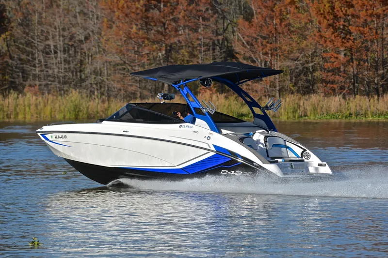 Slide: The Image of 2018 Yamaha Boats 242X cruising on a lake with autumn trees in the background. - 4