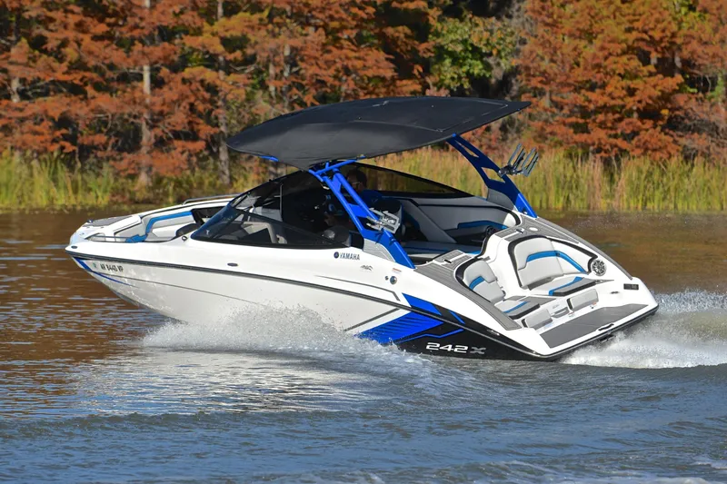 Slide: The Image of 2018 Yamaha Boats 242X cruising on a lake with autumn foliage in the background. - 6