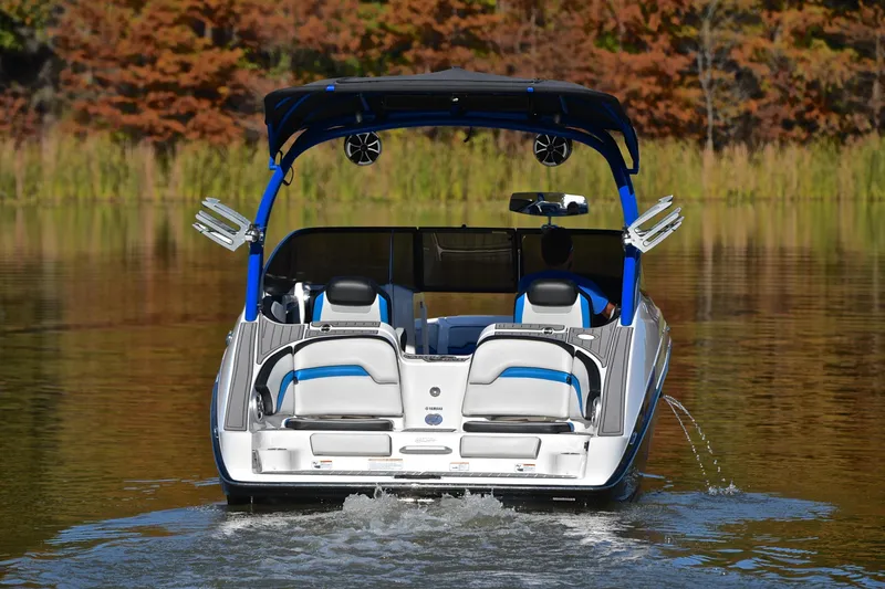 Slide: The Image of 2018 Yamaha Boats 242X on a calm lake with autumn foliage backdrop. - 8