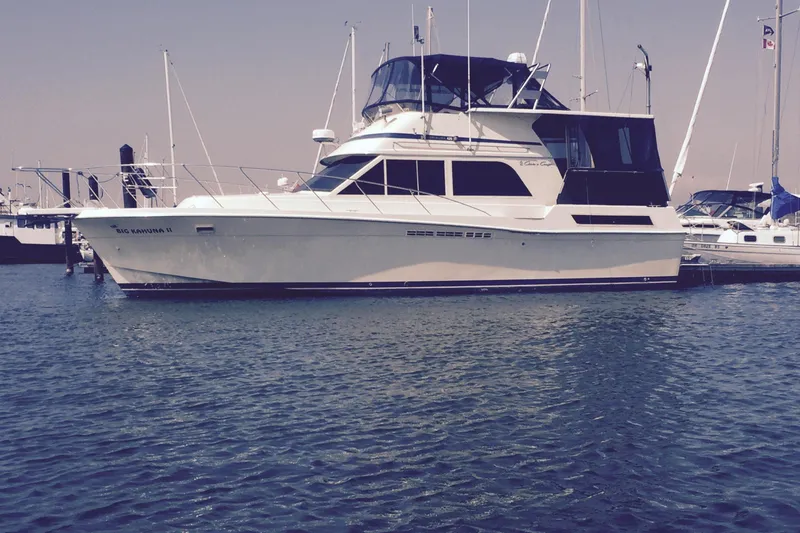 The Image of 1986 Chris-Craft 426 Catalina yacht docked in a marina, calm water, clear sky. - 0