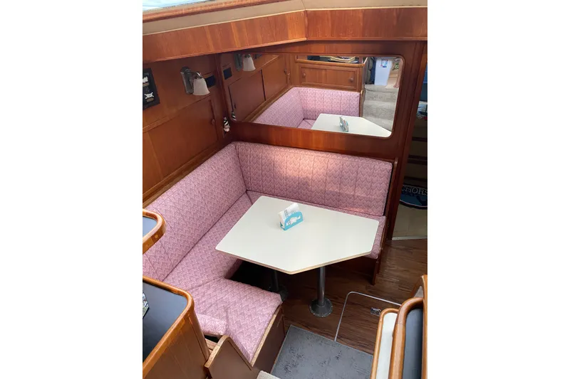Slide: The Image of 1986 Chris-Craft 426 Catalina interior with pink seating and white table. - 10