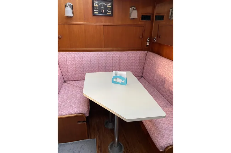 Slide: The Image of 1986 Chris-Craft 426 Catalina interior with pink seating and white table. - 13
