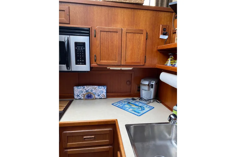 Slide: The Image of 1986 Chris-Craft 426 Catalina kitchen with wooden cabinets, microwave, and coffee maker. - 14