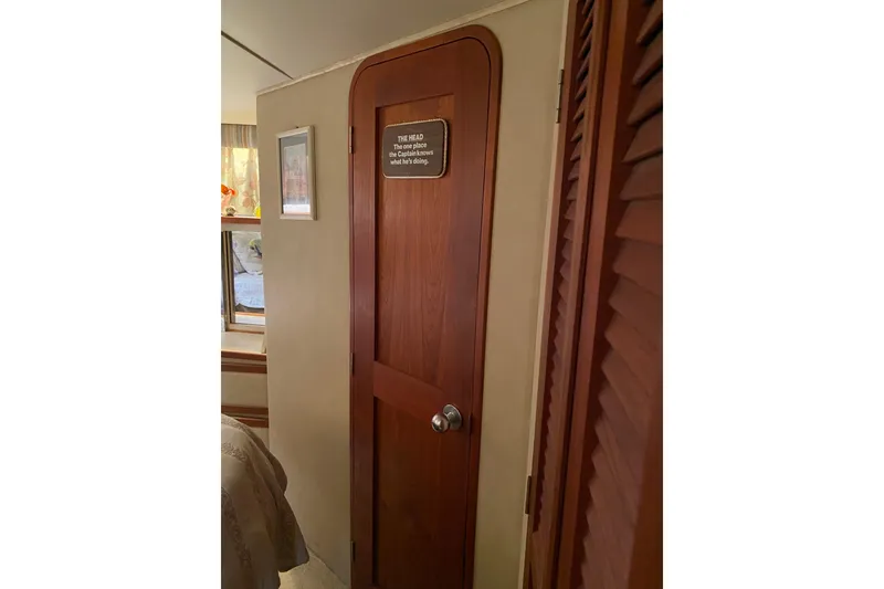 Slide: The Image of Interior of 1986 Chris-Craft 426 Catalina with wooden door and humorous sign. - 17