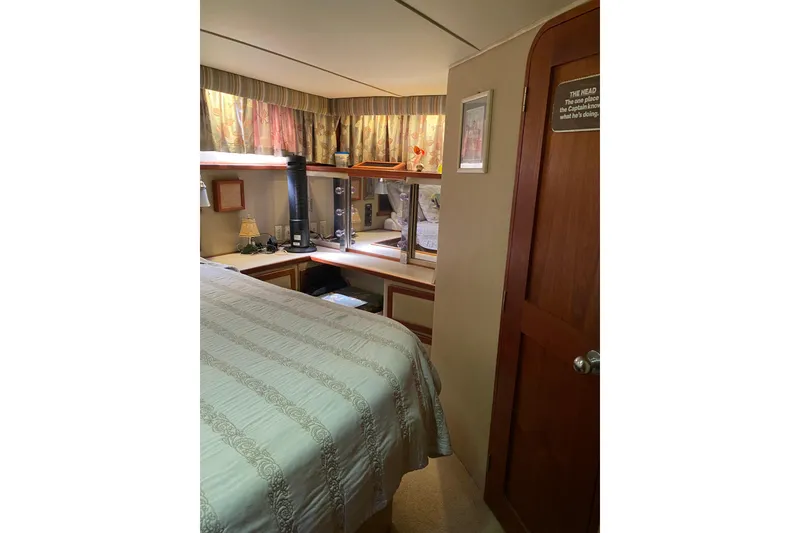 Slide: The Image of Cozy interior of 1986 Chris-Craft 426 Catalina yacht bedroom with wood accents and decor. - 21