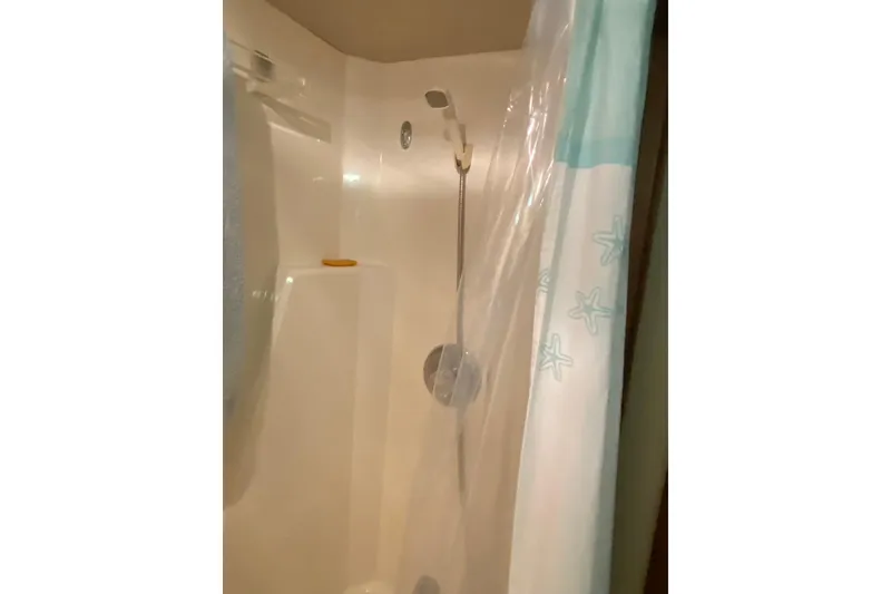 Slide: The Image of Shower area inside 1986 Chris-Craft 426 Catalina boat with starfish-patterned curtain. - 24