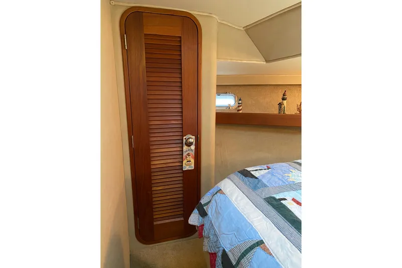 Slide: The Image of 1986 Chris-Craft 426 Catalina cabin interior with wooden door and quilted bedspread. - 25
