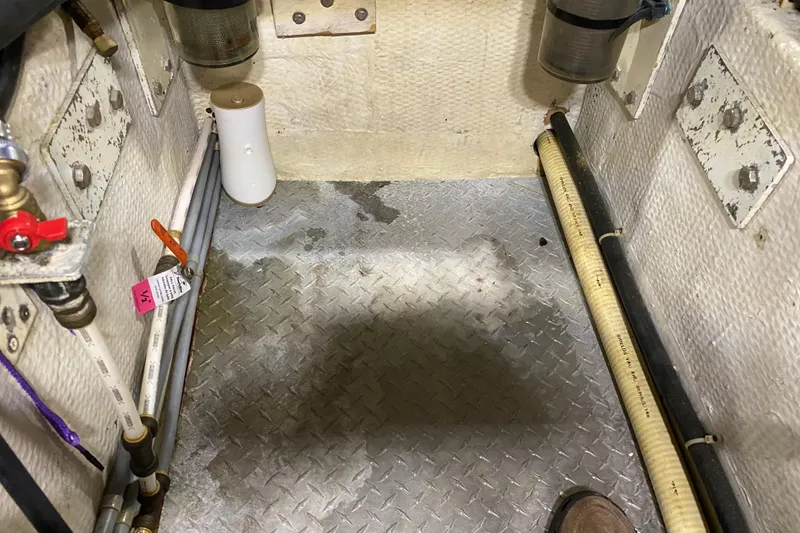 Slide: The Image of Engine room of 1986 Chris-Craft 426 Catalina with pipes and metal flooring. - 42