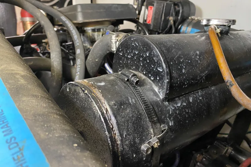 Slide: The Image of Engine components of a 1986 Chris-Craft 426 Catalina boat, showing hoses and metal parts. - 48