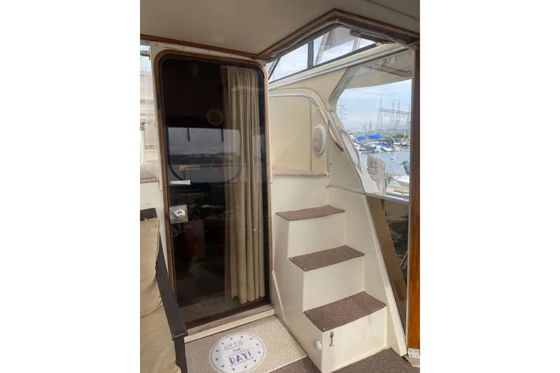 Slide: The Image of Interior view of 1986 Chris-Craft 426 Catalina yacht with stairs and marina background. - 52