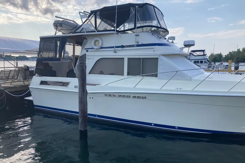Slide: The Image of 1986 Chris-Craft 426 Catalina yacht docked at marina under cloudy sky. - 54