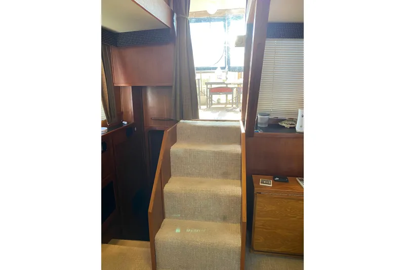 Slide: The Image of Interior view of 1986 Chris-Craft 426 Catalina yacht with carpeted stairs and wooden cabinetry. - 7