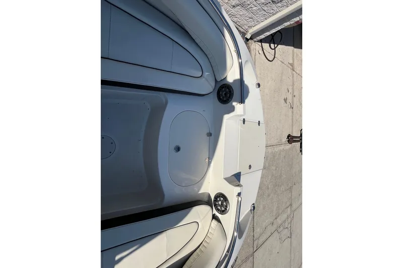 Slide: The Image of 2020 Stingray 201DS boat interior with seating and speakers, docked on concrete. - 11