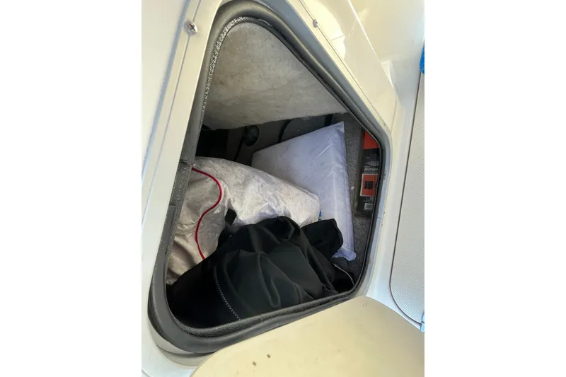 Slide: The Image of Storage compartment of a 2020 Stingray 201DS boat with various items inside. - 19