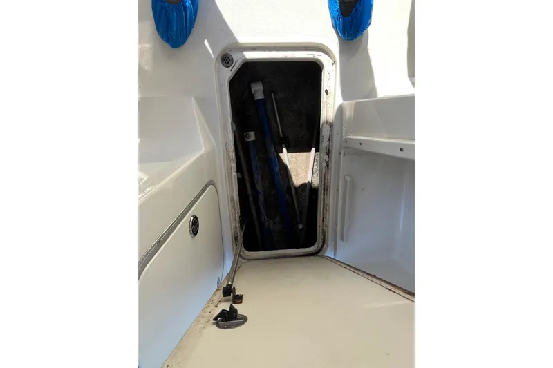 Slide: The Image of 2020 Stingray 201DS boat interior storage compartment with open hatch and visible equipment. - 20