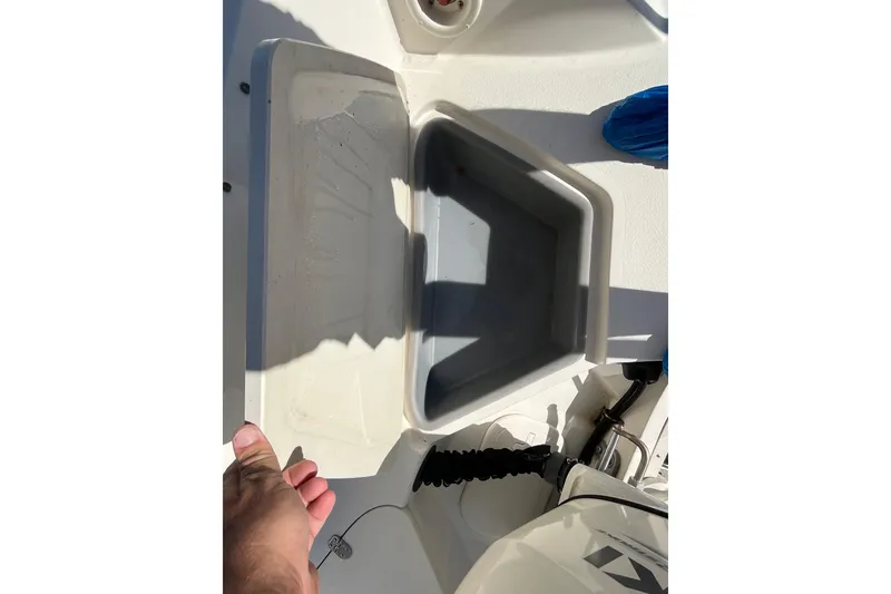 Slide: The Image of 2020 Stingray 201DS boat storage compartment with open lid, showcasing interior space. - 38