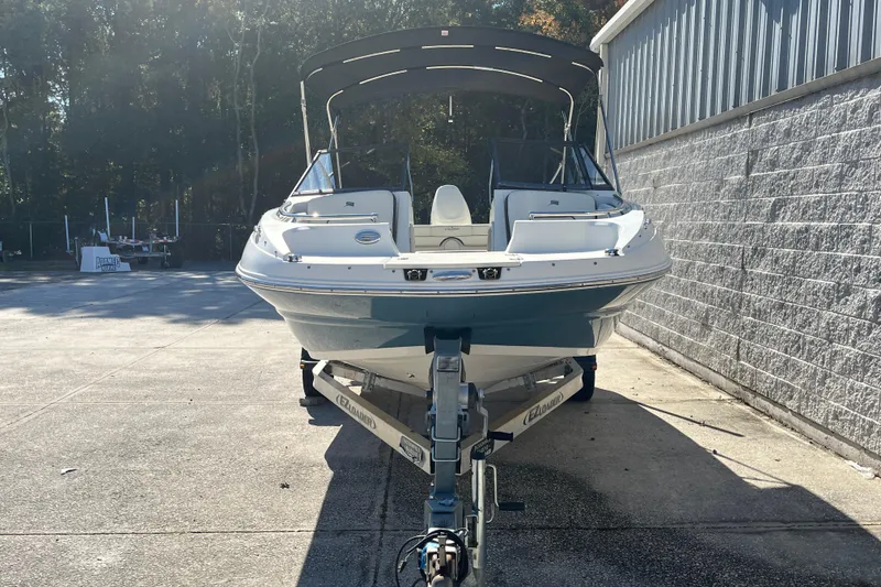 Slide: The Image of 2020 Stingray 201DS boat on trailer, parked outdoors near a building. - 4