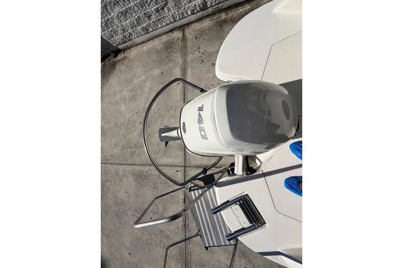 Slide: The Image of 2020 Stingray 201DS boat with outboard motor and swim ladder on concrete surface. - 40