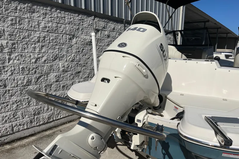 Slide: The Image of 2020 Stingray 201DS boat with Suzuki outboard motor, parked near a brick wall. - 41
