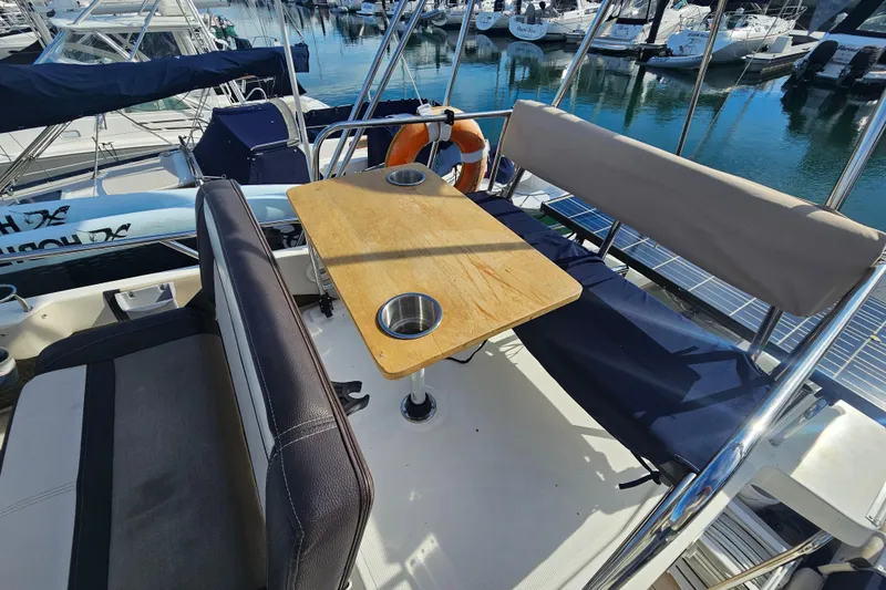Slide: The Image of 2015 Cutwater 30 Command Bridge boat interior with seating and table at marina. - 14
