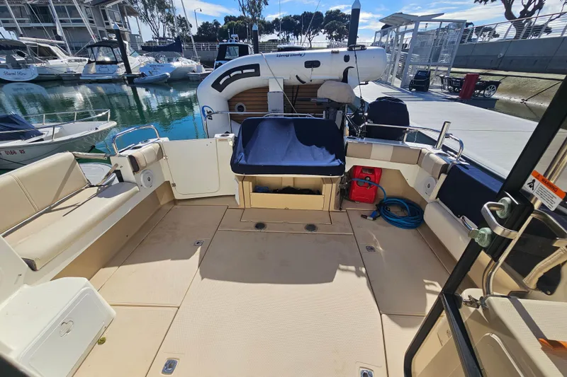 Slide: The Image of 2015 Cutwater 30 Command Bridge boat interior at marina, featuring spacious seating and equipment. - 16