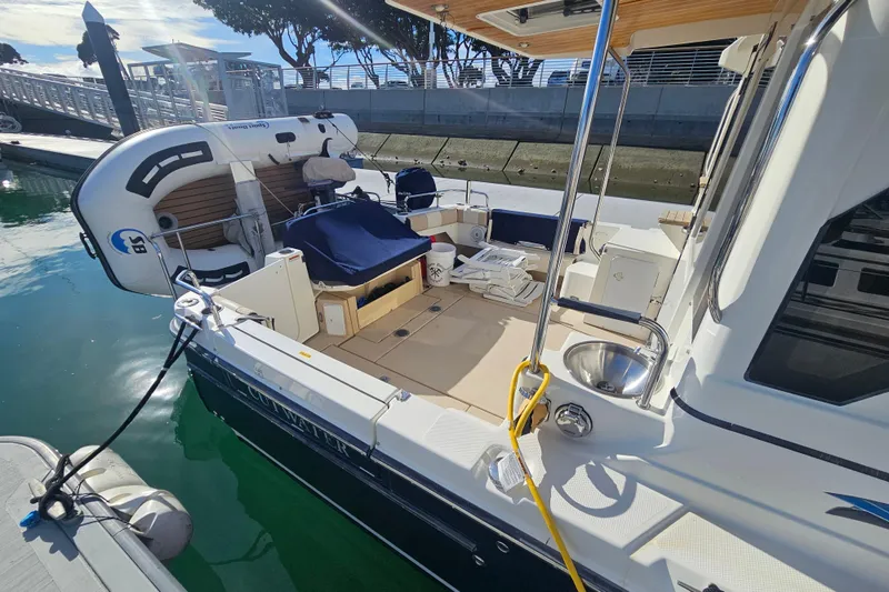 Slide: The Image of 2015 Cutwater 30 Command Bridge docked, featuring spacious deck and inflatable dinghy. - 17