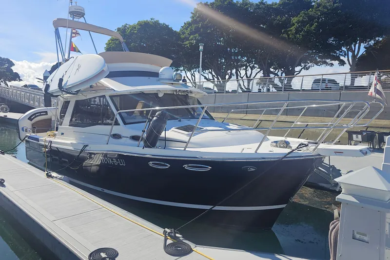 Slide: The Image of 2015 Cutwater 30 Command Bridge docked at marina under clear sky. - 2