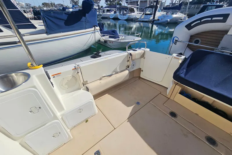Slide: The Image of 2015 Cutwater 30 Command Bridge boat interior, featuring deck and storage compartments at marina. - 20