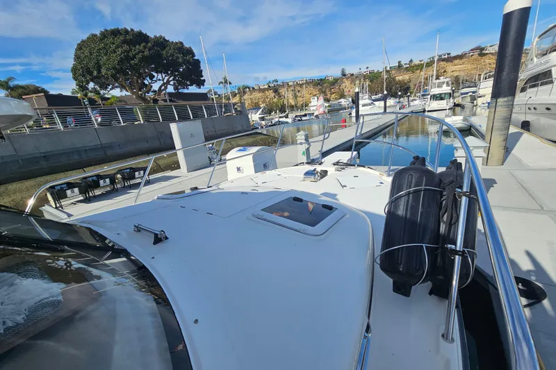 Slide: The Image of 2015 Cutwater 30 Command Bridge docked at marina, clear sky, calm water. - 23