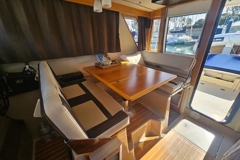 Slide: The Image of Interior of 2015 Cutwater 30 Command Bridge with dining area and marina view. - 29