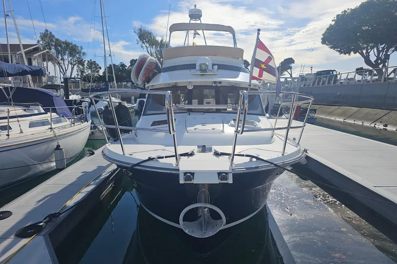 Slide: The Image of 2015 Cutwater 30 Command Bridge docked at marina, front view with flag. - 3