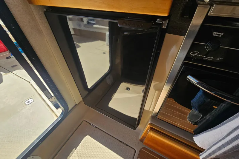 Slide: The Image of Interior of a 2015 Cutwater 30 Command Bridge boat, featuring a compact kitchen area. - 38