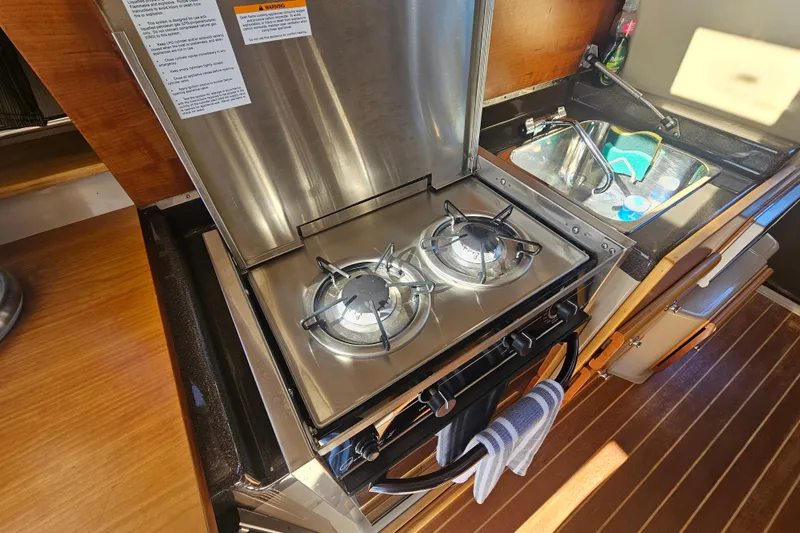 Slide: The Image of Compact kitchen with dual-burner stove in 2015 Cutwater 30 Command Bridge boat. - 40