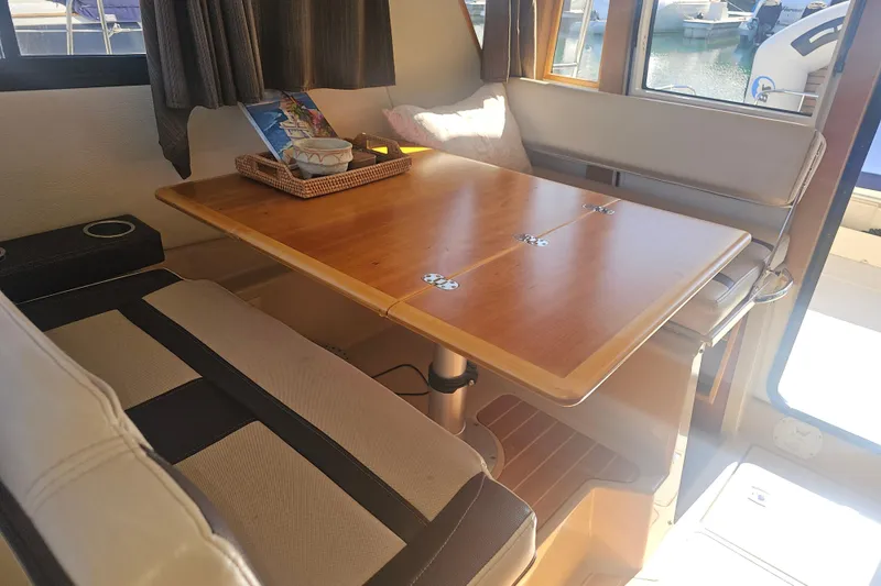 Slide: The Image of Interior of 2015 Cutwater 30 Command Bridge with wooden table and cushioned seating. - 41