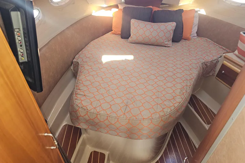 Slide: The Image of 2015 Cutwater 30 Command Bridge cabin with cozy bed and patterned bedding. - 45