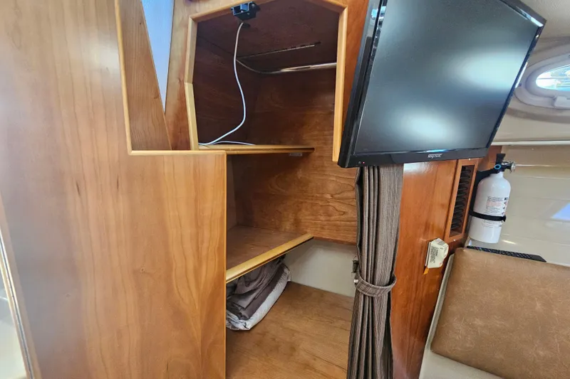 Slide: The Image of Interior of 2015 Cutwater 30 Command Bridge with TV, shelves, and fire extinguisher. - 47